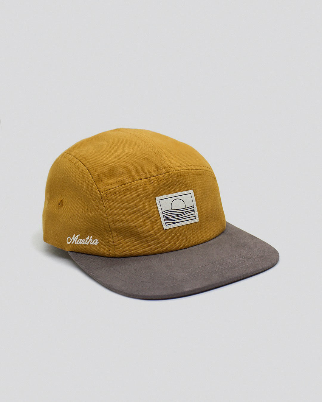 5 panel hat golden brown and gray with sunset ove r the sea label, made with recycled polyester